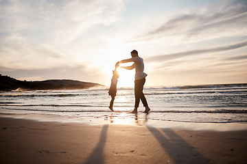 Image showing Love, swing and father with girl child at a beach holding hands in nature for play, freedom or bond at sunset. Ocean, travel and parent with kid at sea for spinning fun, games or celebration in Bali