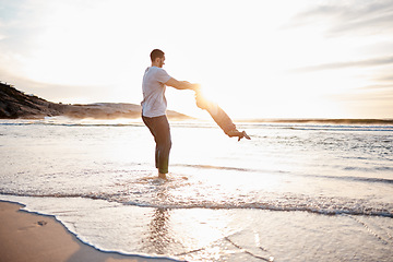 Image showing Swing, beach and father with playing child holding hands in nature for freedom or bonding at sunset. Ocean, travel and parent with girl at sea for spinning fun, games or celebration adventure in Bali