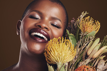 Image showing Skincare, nature and plant with the face of a black woman in studio on brown background for natural treatment. Beauty, protea or cosmetics and a young model for aesthetic wellness with flowers