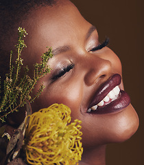 Image showing Face, beauty and protea with the smile of a black woman in studio on brown background for natural treatment. Happy, plant or cosmetics and a young model indoor for aesthetic wellness with flowers