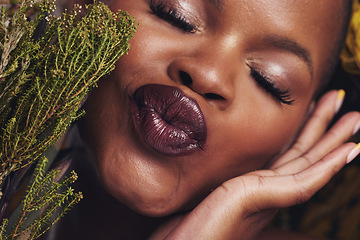 Image showing African woman, plants and makeup in studio with kiss, beauty and wellness with lipstick, skin and closeup. Girl, model and face with leaves, pouting or happy for cosmetics, shine or aesthetic in zoom