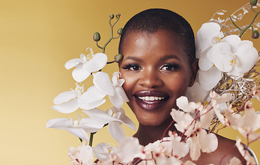 Image showing Black woman, flowers and beauty with portrait, smile with makeup and natural cosmetics isolated on studio background. African model, orchid and nature, sustainable skincare and with facial and glow