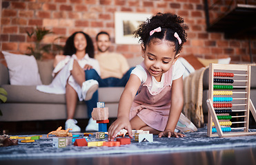 Image showing Child, toys and playing in home with development and building block in living room. Family, fun and youth learning with a young girl and parents in a house together with care and bonding education