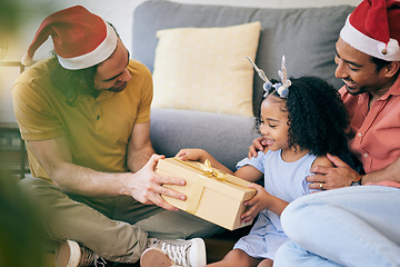 Image showing Gay, Christmas and a father with a gift for a child, celebration and holiday as a family. Smile, home and an lgbt man with a festive present for a girl kid in the living room of a house together