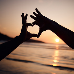 Image showing Beach sunset, nature silhouette and person with heart hands sign for love, freedom and ocean vacation. Adventure, emoji health icon and couple support with natural wellness, tropical care or shape