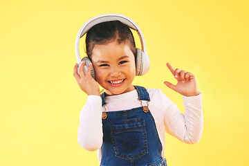 Image showing Girl child, studio portrait and headphones with smile, listening or audio tech by yellow background. Happy female kid, sound and music with streaming subscription, radio and hearing in trendy fashion