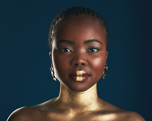 Image showing Gold makeup, studio portrait or black woman with creative art, facial cosmetics paint and lipstick. African culture, face glow and person with beauty design, wellness or creativity on blue background