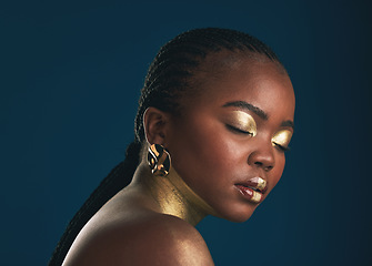 Image showing Gold makeup, studio face and black woman relax with creative art, facial cosmetics paint and beauty. African culture, color and person with eyes closed, wellness and creativity on blue background