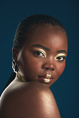 Image showing Gold makeup, portrait and black woman confident with creative art, facial cosmetics paint and beauty design. African culture, studio or female model with face glow, shine or unique on blue background