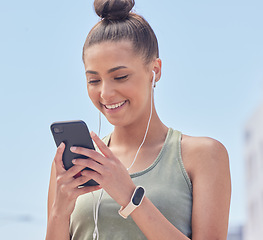 Image showing Happy woman, phone and city in fitness, communication or social media smile for outdoor networking. Female person or runner texting or chatting on mobile smartphone app with earphones in urban town