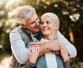 Image showing Love, hug and senior couple at a park happy, free and enjoy travel, holiday or weekend outdoor. Face, smile and elderly man embrace woman in forest, bond and having fun on retirement trip together