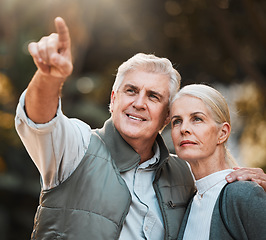 Image showing Senior couple, hiking and pointing in nature, thinking and view with direction, forest and adventure. Elderly man, woman and together with vision, walk or check environment on outdoor holiday in park