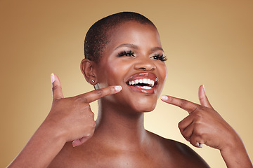 Image showing Teeth, beauty and a woman pointing at smile in studio for skin care, glow or cosmetics. Face of African model person with dental shine, dermatology and makeup announcement on a beige background