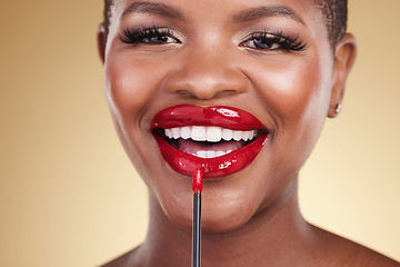 Image showing Makeup brush, beauty and a woman with red lipstick in studio for closeup, glow or cosmetics. Face of happy African person with facial shine, dermatology and application on mouth on a beige background