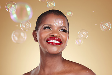 Image showing Smile, makeup and bubbles with face of black woman in studio for cosmetics, spa treatment and luxury. Skincare, dermatology and self care with model on gold background for glow, facial and beauty