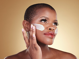Image showing Application, skincare and face cream for black woman in studio for dermatology or cosmetic wellness on brown background. Beauty, hand and model with facial, sunscreen or collagen, mask or scrub
