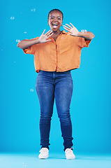 Image showing Excited, portrait and black woman on blue background with bubbles for happiness, joy and have fun. Playful, smile and isolated African person in studio with soap bubble for happy, magic and aesthetic