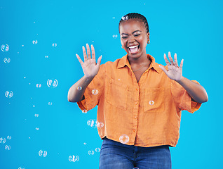 Image showing Excited, laugh and black woman on blue background with bubbles for happiness, joy and have fun. Playful, happy smile and isolated African person in studio with soap bubble for freedom and color