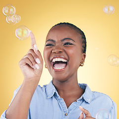 Image showing Excited, laugh and black woman on yellow background with bubbles for happiness, joy and have fun. Happy, smile and isolated African person in studio pop soap bubble for playful magic and color