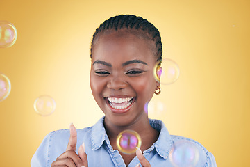 Image showing Excited, pop and black woman on yellow background with bubbles for happiness, joy and fun. Playful, smile and isolated happy African person in studio with soap bubble for freedom, magic or color