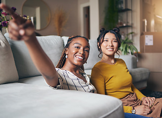 Image showing Pointing, friends and women in living room for visit, bonding and conversation in apartment. Hand gesture, showing house decor and black female and Asian person in lounge to relax together on weekend