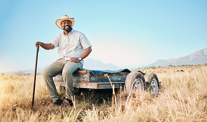 Image showing Portrait, African farmer and land in the countryside and man, sitting and watching over agriculture, field and environment. Farming, meadow and happy worker outdoor with happiness or smile in summer