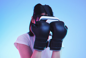 Image showing Vr, fitness and woman boxing in esports, video game and fight in studio on blue background with headset technology. 3d, exercise and virtual reality fighting ux or punching with futuristic gaming