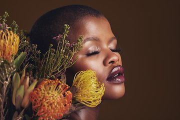 Image showing Black woman, flowers and makeup in studio for beauty, wellness or thinking with protea by brown background. Girl, model and glow on facial skin, sustainable cosmetics and eyes closed for aesthetic