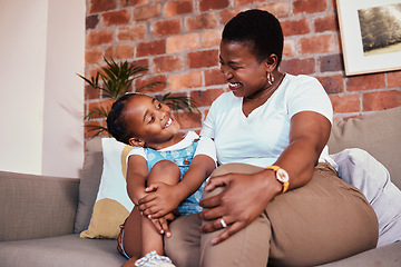 Image showing Happy, relax and a mother on the sofa with a child for conversation, bonding and family in a house. Smile, care and an African mom or woman with a girl kid on the living room couch for talking