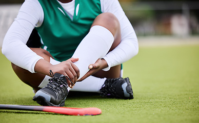 Image showing Hockey, pain and leg injury by woman player on a field with problem, joint or muscle crisis in sport. Hand holding, ankle and athlete with emergency, inflammation or fitness accident from training