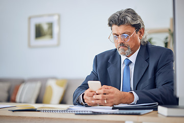 Image showing Phone, networking and mature businessman in the office typing a text message on social media. Serious, technology and professional male lawyer browsing on the internet with a cellphone in workplace.