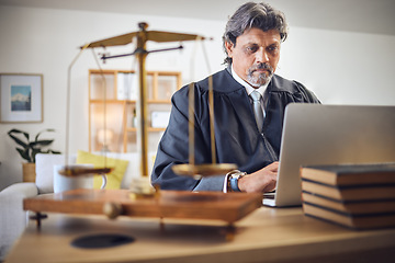 Image showing Scales, justice and man in office with laptop for working in law firm, court research or search online for legal policy or rules. Judge, attorney or mature businessman with communication on computer