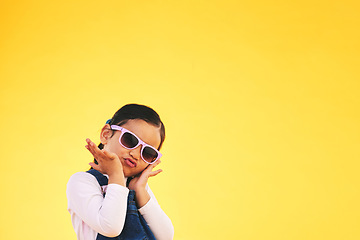 Image showing Girl, child and portrait with sunglasses in studio for confidence, cool and fun attitude. Face, space and young kid with mockup, pose and fashion announcement isolated on a yellow background