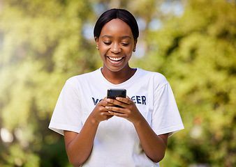 Image showing Chat, park volunteering and black woman with a phone for social media, email or communication. Happy, web and African volunteer or charity worker in nature for cleaning with a mobile for notification