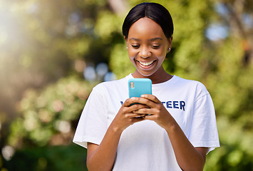 Image showing Smile, park volunteering and black woman with a phone for social media, chat or communication. Happy, web and African volunteer or charity worker in nature for cleaning with a mobile for notification