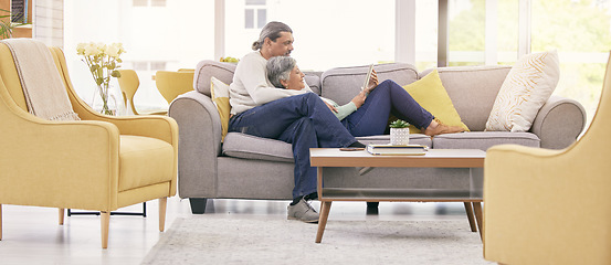 Image showing Mature couple, relax and together on sofa with tablet for streaming a film, show or movie in home, lounge or living room. Love, man and woman in retirement watching tv on mobile app or social media