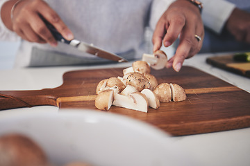 Image showing Cut, mushroom and person hands cooking vegetable in a kitchen on a board or table in a home as healthy a chef. Salad, food and woman prepare produce for a supper, lunch or dinner for diet meal