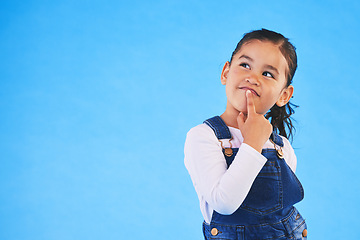 Image showing Thinking, child and girl with ideas, decision and choice on a blue studio background. Mockup space, kid and model with doubt, planning and inspiration with problem solving, question and opportunity