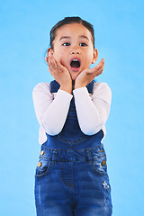 Image showing Shocked, wow and girl with hands to face in studio with fear and scared from danger. Alarm, blue background and young child from Hawaii with scary, omg surprise and emoji face of a kid in danger