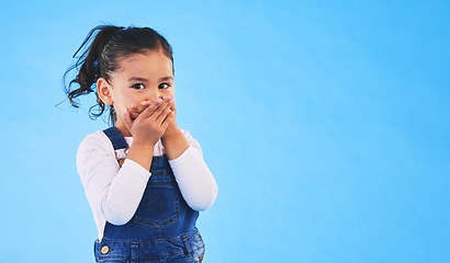 Image showing Girl child, cover mouth and studio portrait with mockup space for promotion, secret or sale by blue background. Female kid, silence and hands on lips for deal, news and fashion model with information