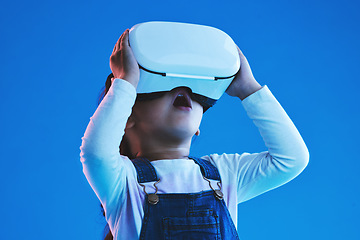 Image showing Wow, virtual reality and metaverse with girl, glasses and online gaming on a blue studio background. Person, kid or child with vr headset, augmented reality or digital transformation with video games