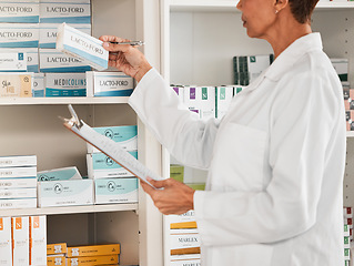 Image showing Woman, pharmacist and inventory inspection on pills, tablets or medication on shelf at the pharmacy. Female person, medical or healthcare worker checking stock or pharmaceutical products at drugstore