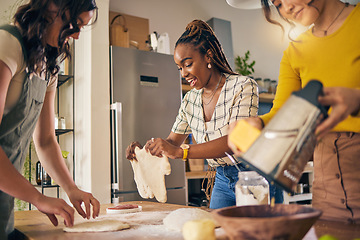 Image showing Cooking, friends and food with women in kitchen for pizza, support and nutrition. Happy, bonding and help with group of people and preparing lunch at home for conversation, diversity and health