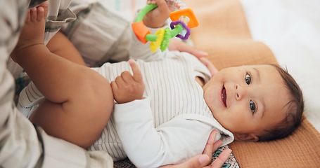 Image showing Baby child, rattle toys and bed with mother, playing or care in family home for learning with childhood development. Portrait, infant kid and excited for games, bonding and happy with mom in nursery