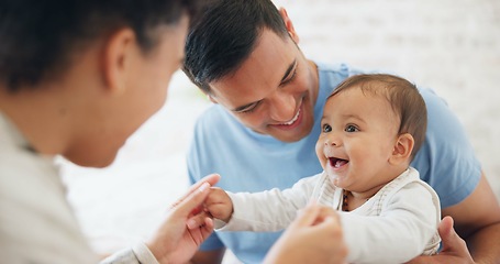 Image showing Baby, playing and father with mom in bedroom with happiness with love or care on weekend. Happy, infant and playful with parents or dad for bonding at family home with funny expression or newborn.