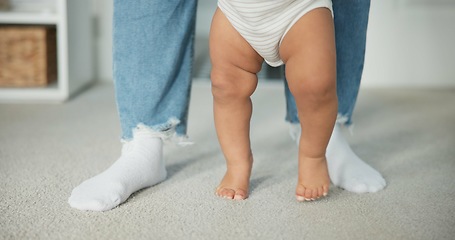 Image showing Legs, baby learning to walk with parents and growth, development and early childhood with motor skills. Family, support and first steps with trust, progress and balance with milestone and feet