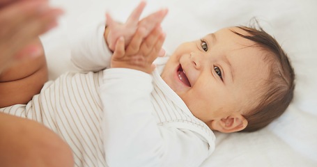 Image showing Infant baby, clapping hands and bed with parent, care or learning with smile, love or childhood development. Young happy kid, nursery or bedroom with teaching, applause or excited face in family home