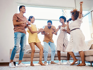 Image showing Karaoke, party and friends dancing in the living room with a microphone to music, playlist or radio. Happy, diversity and young people singing, moving and having fun together for bonding at home.