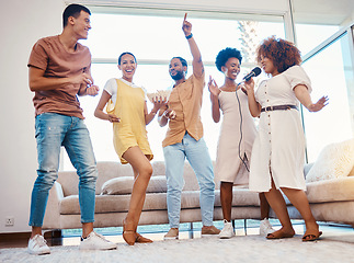 Image showing Singing, entertainment and friends dancing in living room with a microphone to music, playlist or radio. Happy, diversity and young people moving, bonding and having fun together with karaoke at home