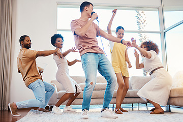 Image showing Karaoke, group and friends singing in the living room with a microphone to music, playlist or radio. Happy, diversity and young people dancing, bonding and having fun together with a song at home.